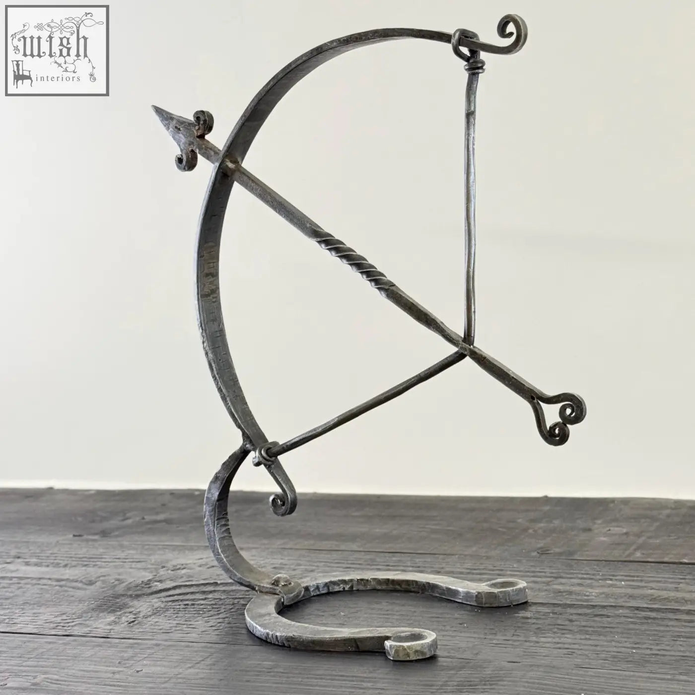 Armillary arrow solid wrought iron sculpture featuring twisted string, ornate scrollwork, and hammer marks in archer sculpture design