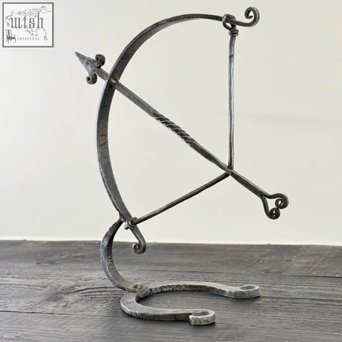 Armillary arrow solid wrought iron sculpture featuring twisted string, ornate scrollwork, and hammer marks in archer sculpture design