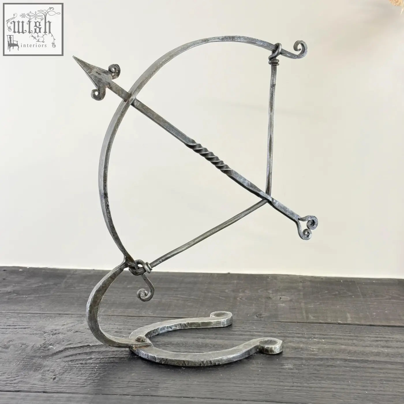 Forged iron armillary arrow sculpture with ornate scrollwork, solid iron with visible hammer marks, archer sculpture design
