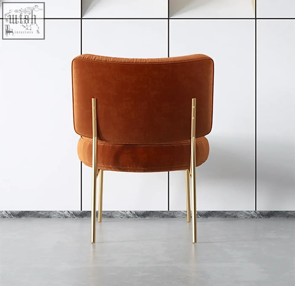 Aron dining chair with plush burnt orange velvet upholstery and slender painted steel gold legs for dining seating