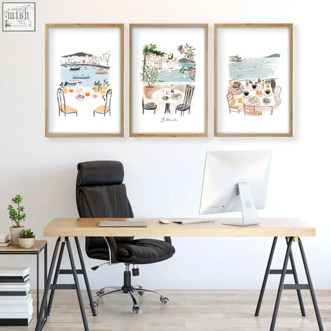 Set of three framed watercolor art prints featuring mediterranean coastal dining scenes in light wood frames