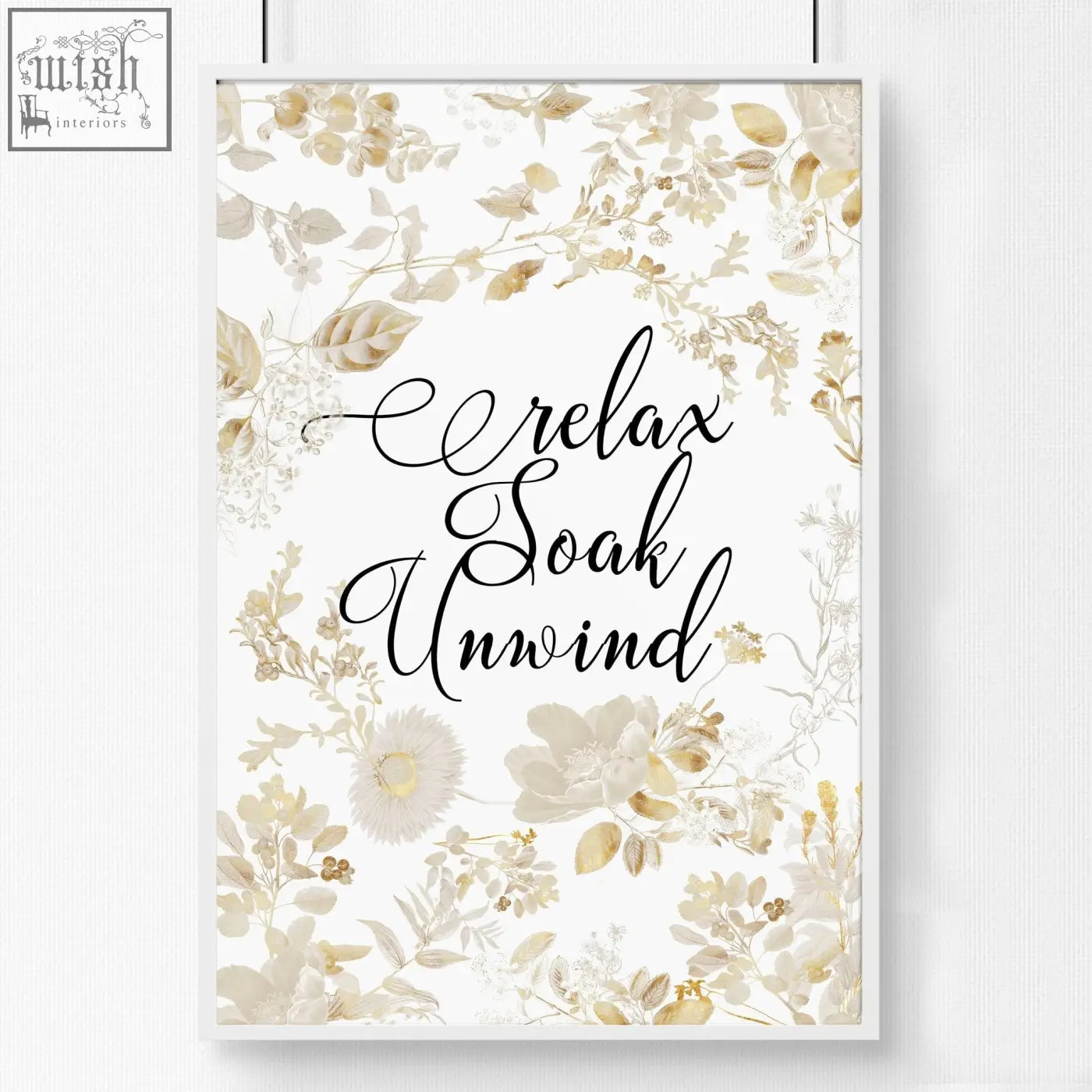 A framed wall art print with black cursive relax soak unwind text and gold cream floral design for bathroom walls