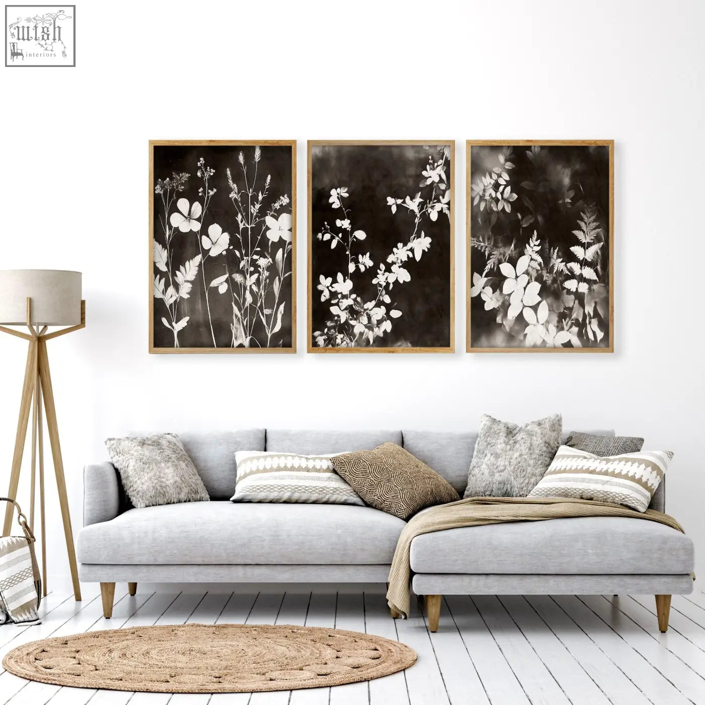 Three framed black and white botanical prints with delicate floral silhouettes in light wood frames for living room wall