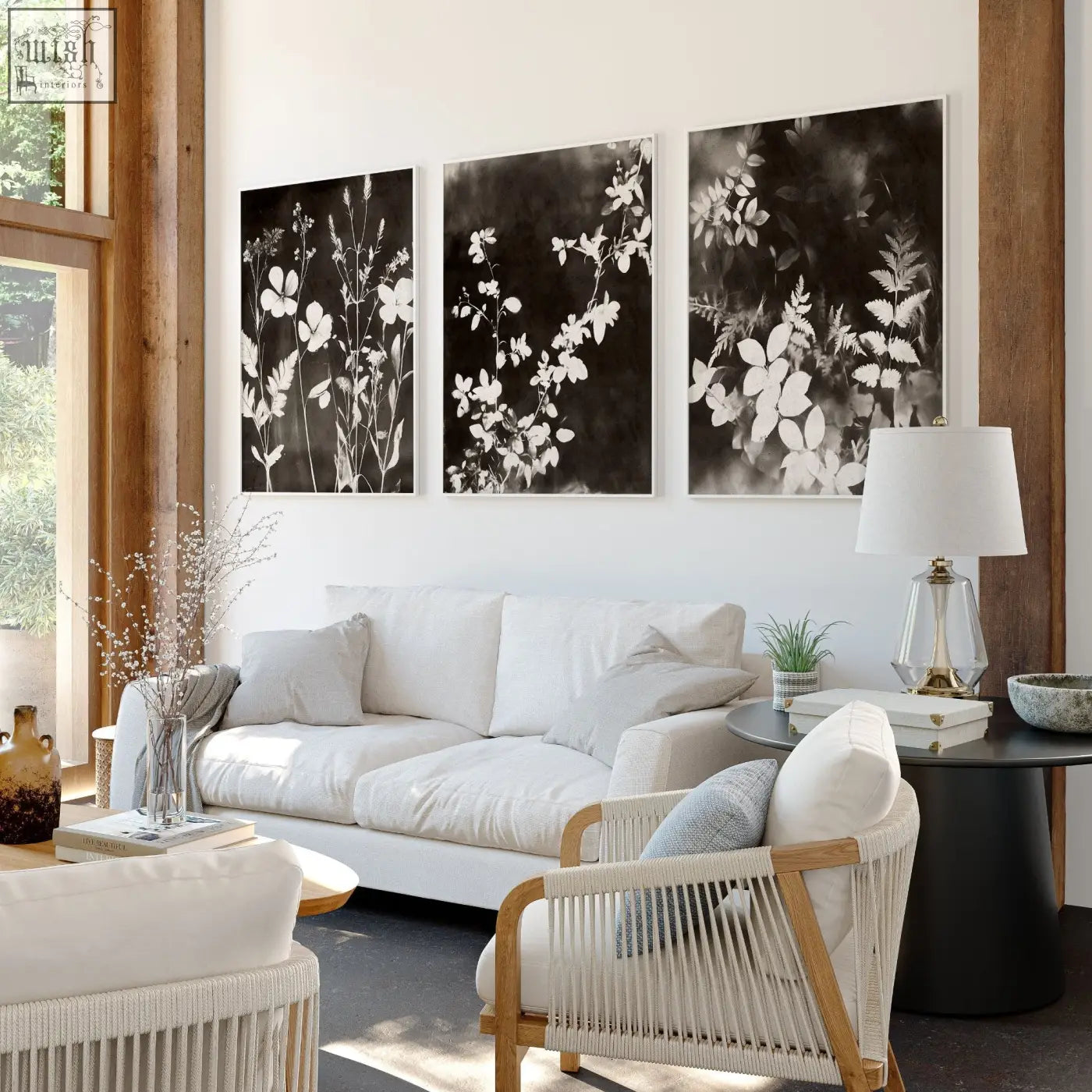 White woven wicker armchair with light wood frame next to dark floral mink botanical living room wall art prints set of 3