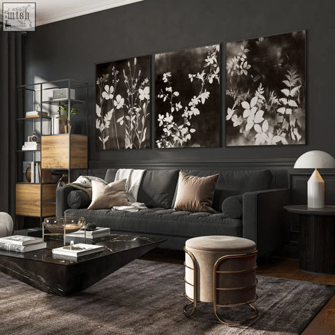 Dark gray upholstered sofa with plush cushions next to mink botanical dark floral wall art prints for living room wall