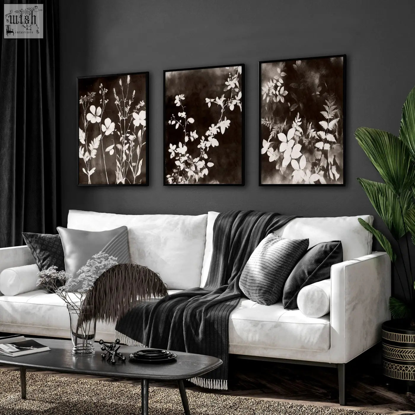 Three framed mink botanical dark floral wall art prints with white floral silhouettes hang on living room wall above sofa