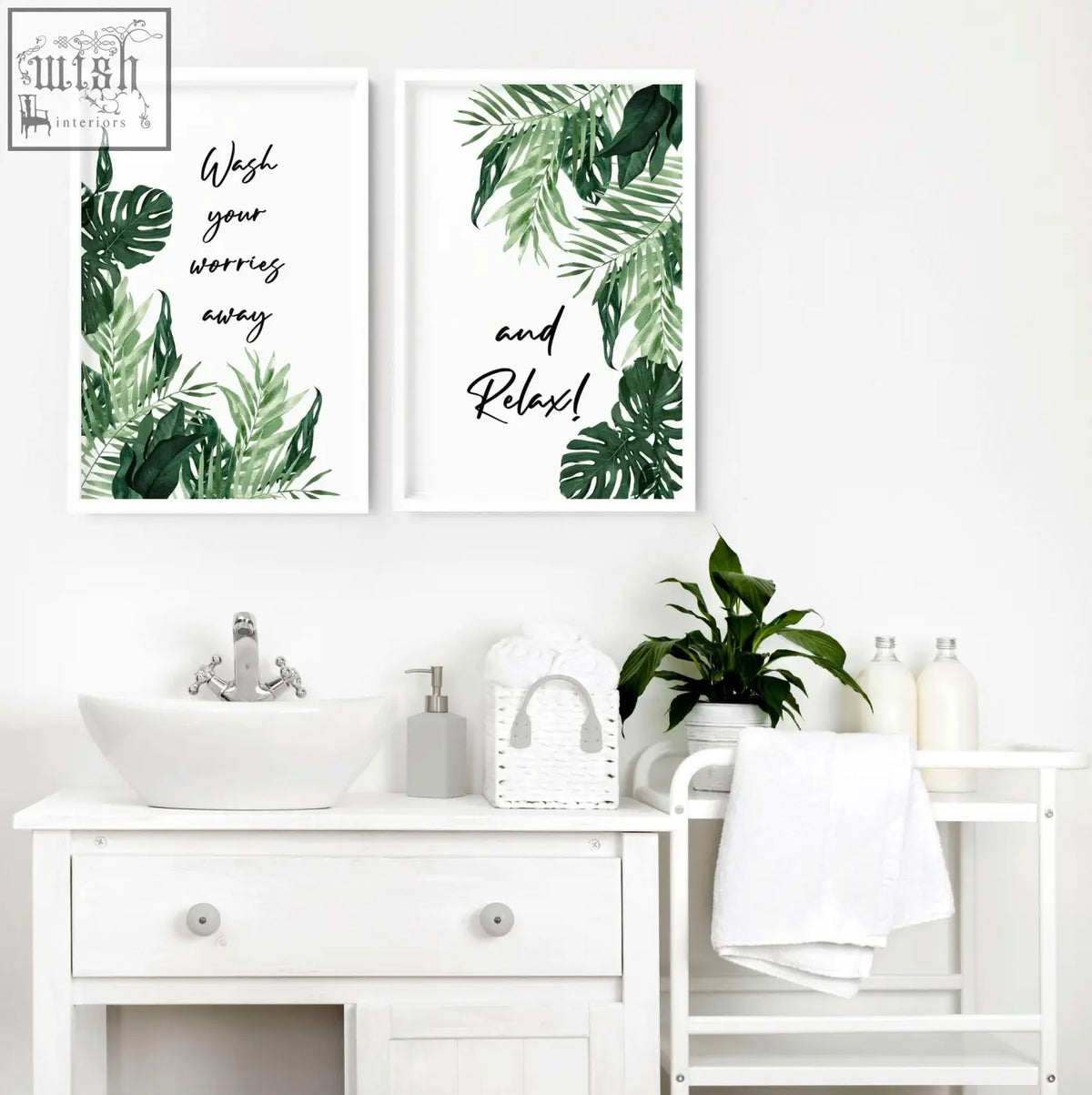 Two framed green leaf wall art prints with black cursive text above a white bathroom vanity in set of 2