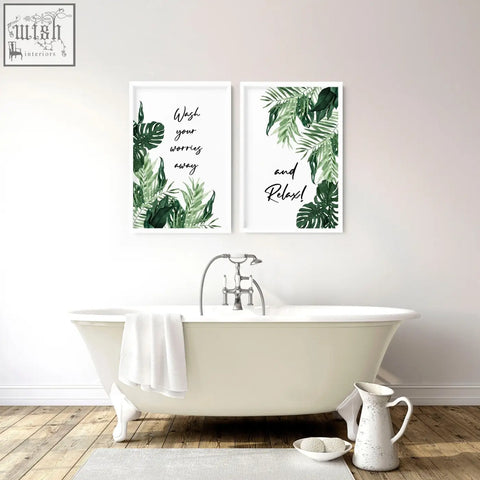 White clawfoot bathtub with silver faucet and towel next to modern wall art prints for bathroom decor