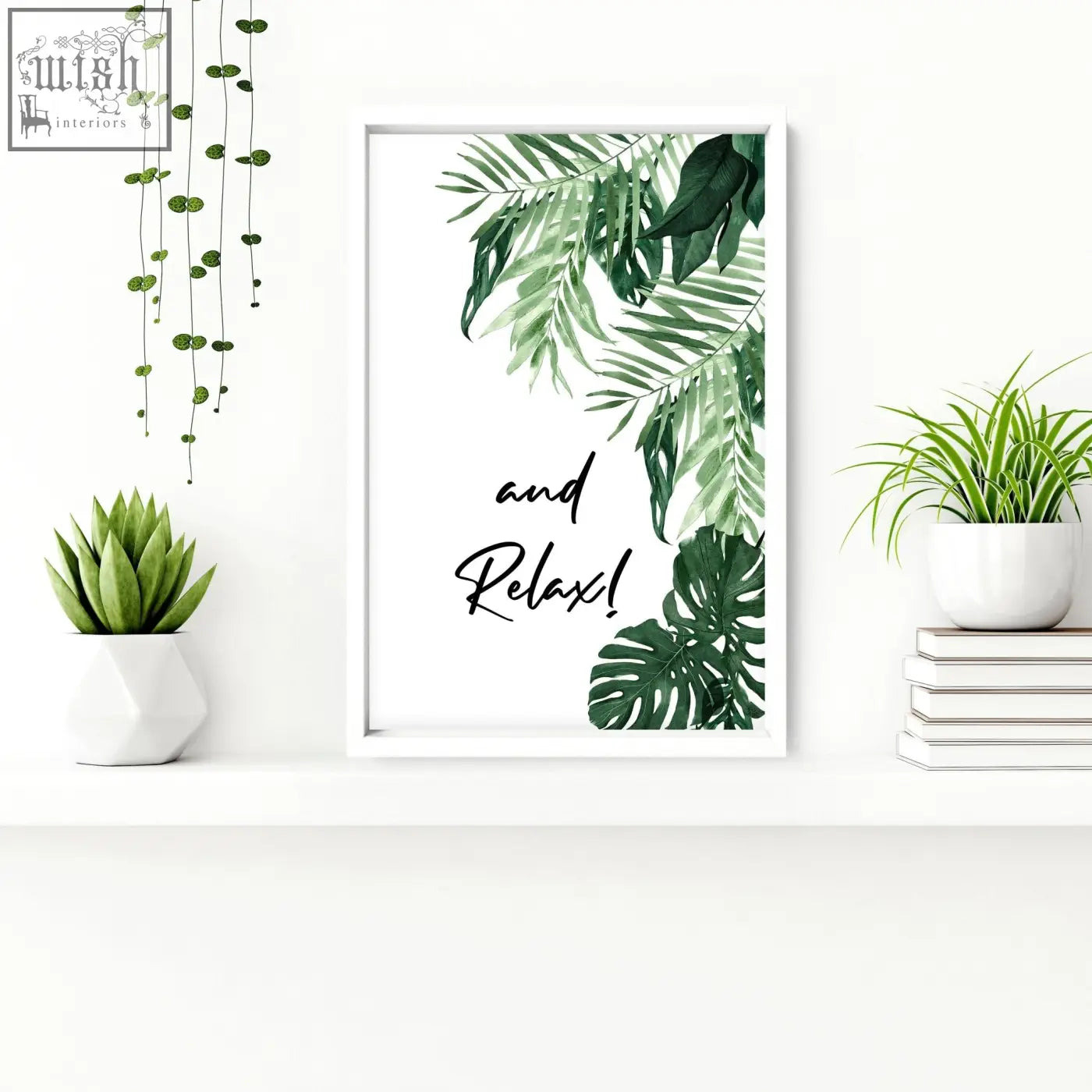White-framed wall art prints with green tropical leaves and black cursive text and relax for bathroom decor