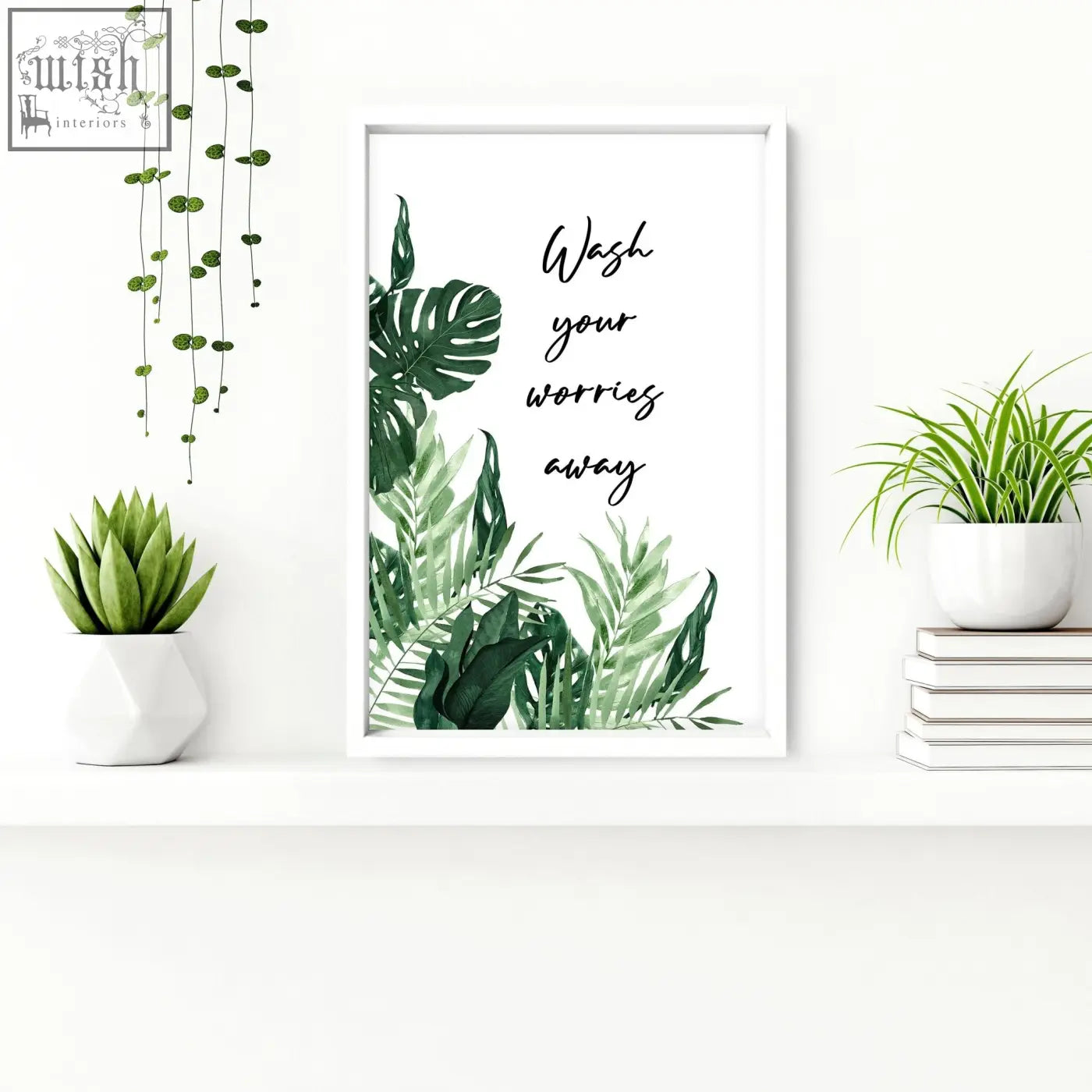 White-framed wall art prints with green tropical leaves and wash your worries away script perfect for bathroom decor