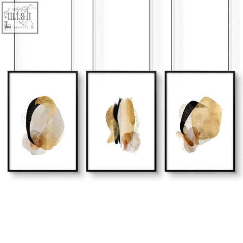 Set of 3 modern abstract art prints with gold beige watercolor splashes in black frames perfect for bedroom walls
