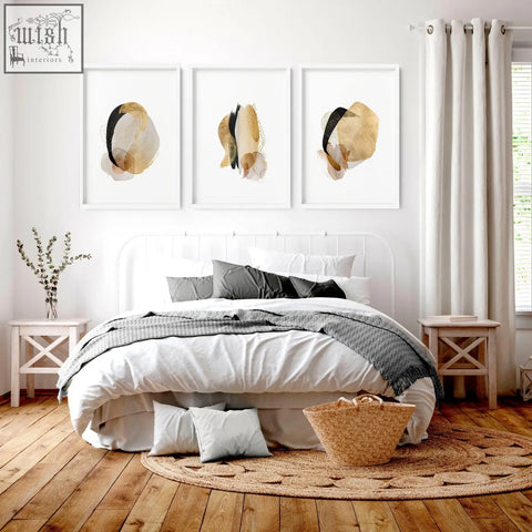 Woven wicker basket with natural tan hue and textured handcrafted look next to abstract art prints for bedroom wall decor