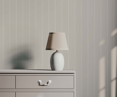 Arthur minimalist white ceramic table lamp with beige fabric shade on dresser complements minimal pinstripe wallpaper