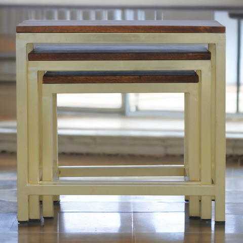 Set of three nesting tables with cream metal frames and dark solid mango wood tops for stylish storage