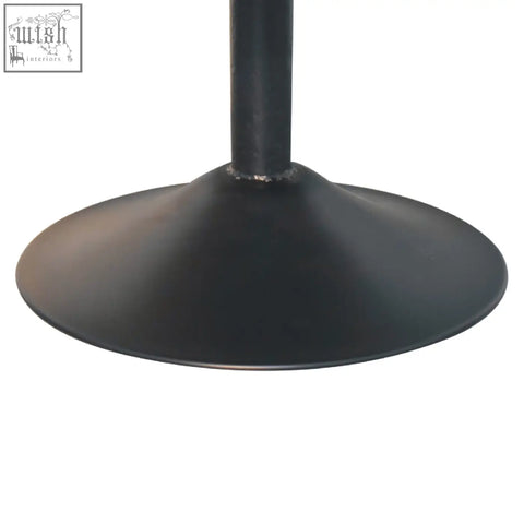 Black matte metal table base with circular flared design paired with cream boucle swivel chair from Artisan Furniture