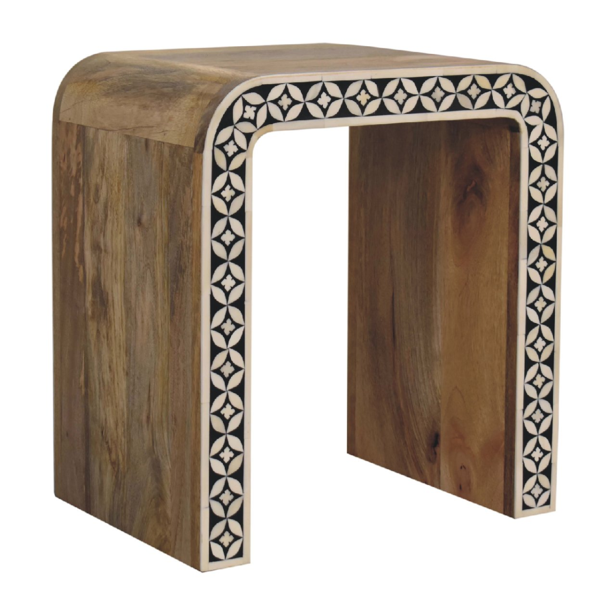 A rustic solid mango wood end table with a curved top and black and white inlaid geometric pattern edges