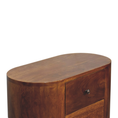 A sleek oval solid mango wood nightstand with rich brown finish and a single drawer with silver knob