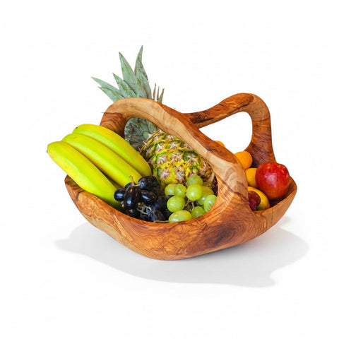 Handcrafted olive wood fruit basket with natural grain and curved handles filled with assorted fresh fruits