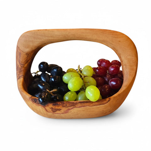 Handcrafted olive wood fruit basket with integrated handle and smooth natural finish perfect for serving in working days