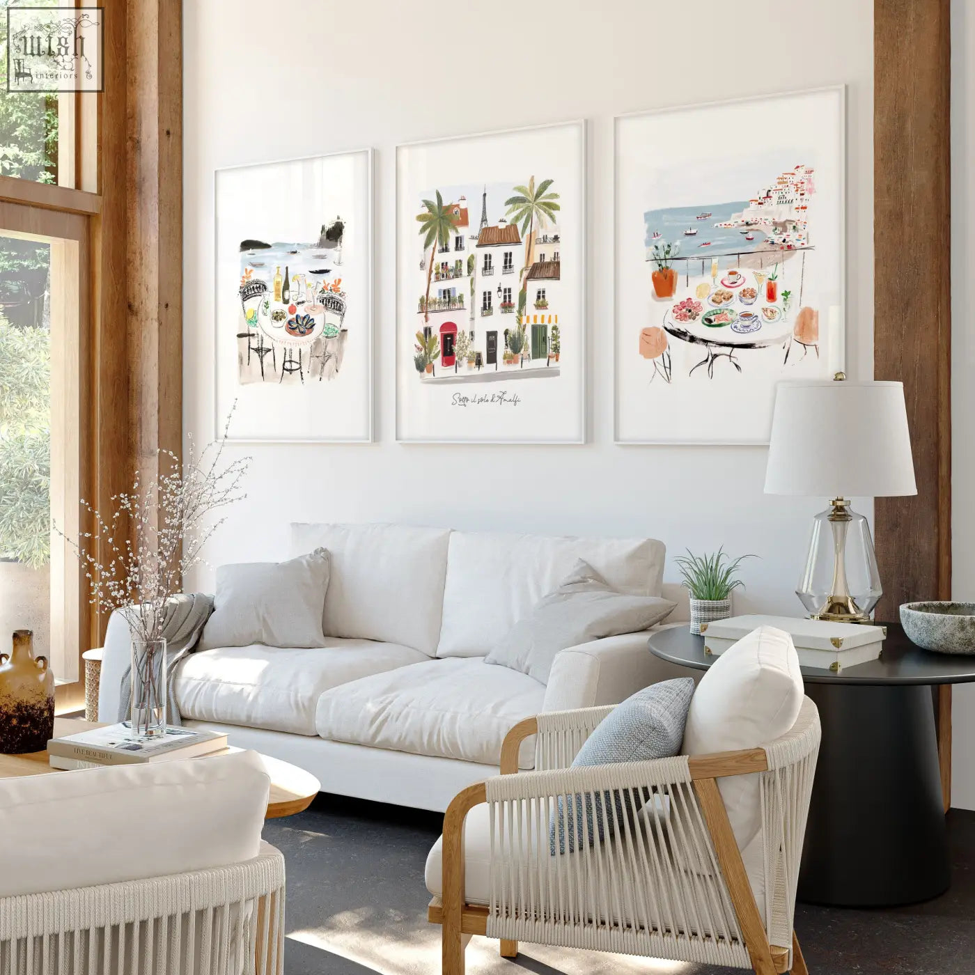 Three framed mediterranean coastal illustrations titled sotto il sole di amalfi hang above a white living room sofa