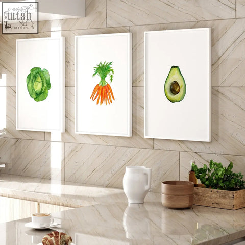 Set of 3 framed wall art featuring watercolor prints of green cabbage orange carrots and halved avocado for kitchen decor