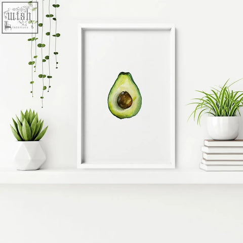 A watercolor avocado halved framed wall art in white perfect for kitchen decor and set of 3 wall art pieces
