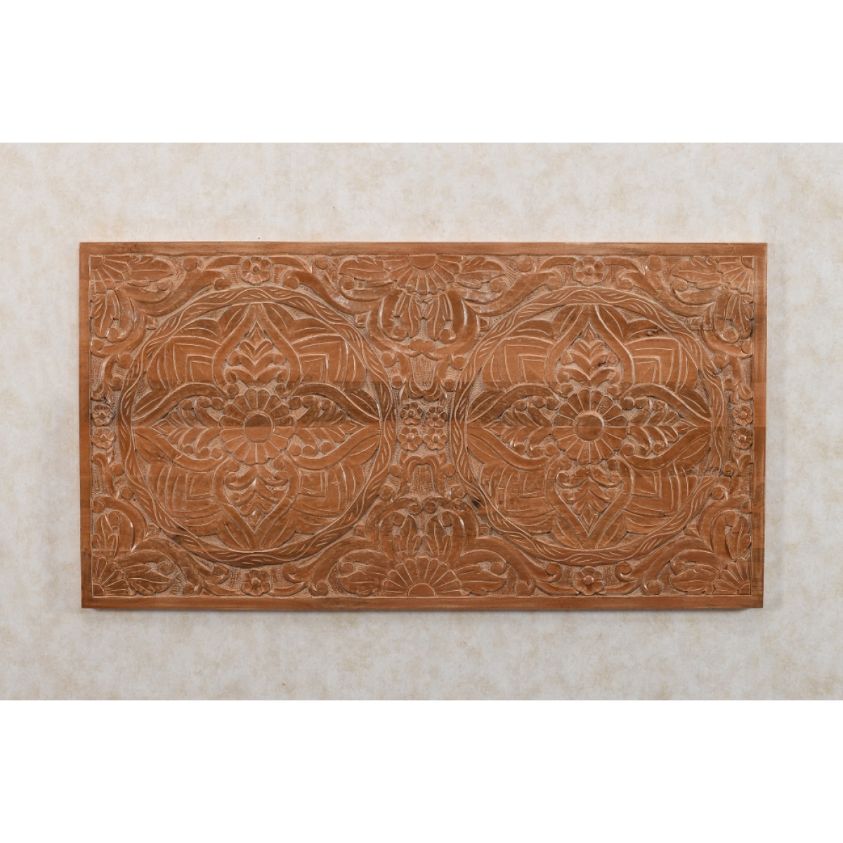 A rectangular light brown mango wood wall art piece with carved floral and geometric patterns for bedframe decor