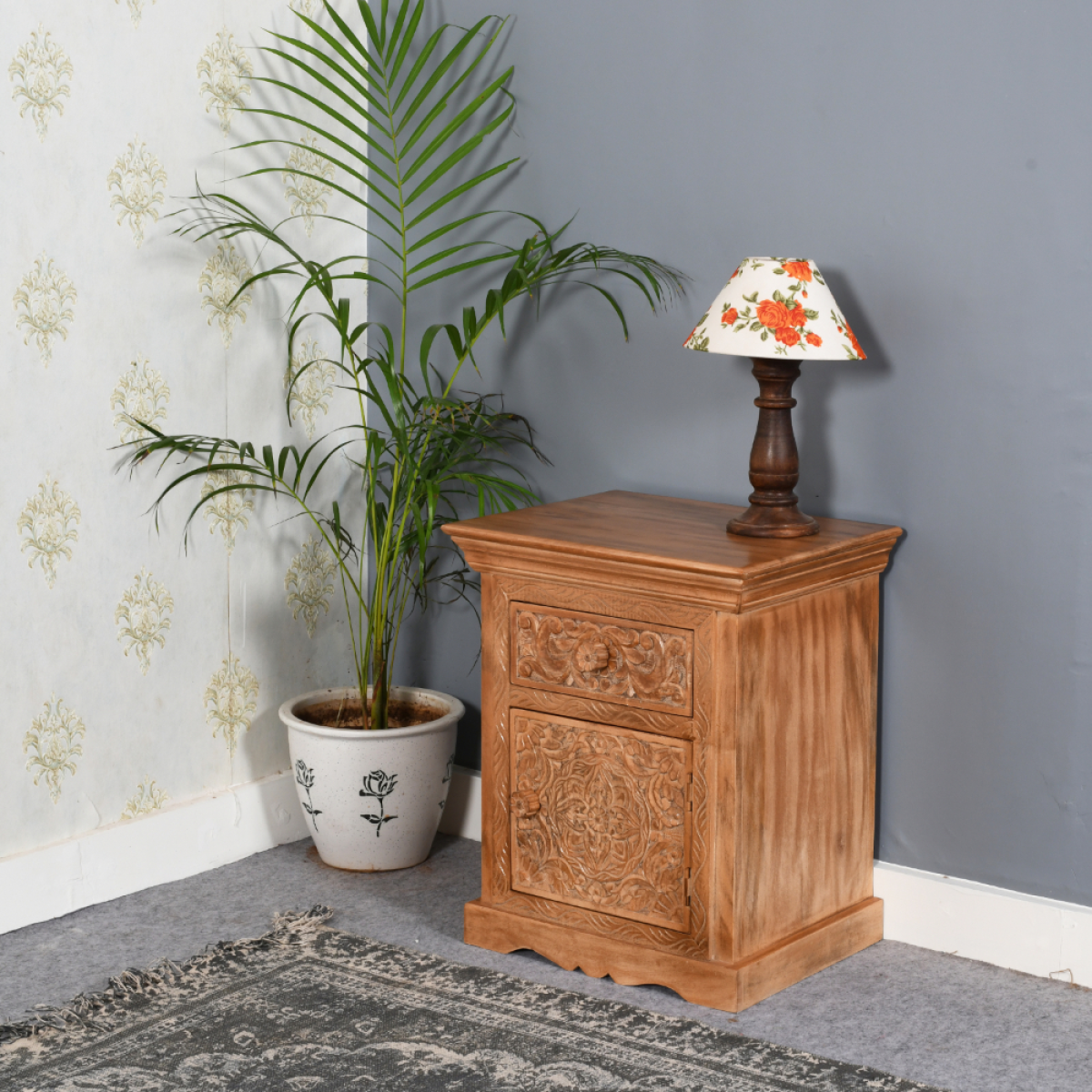 Carved artwork mango wood bedside table with storage featuring warm finish and intricate floral patterns