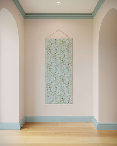 A delicate light blue asian bird tapestry with chinoiserie design featuring branches and birds in a white frame