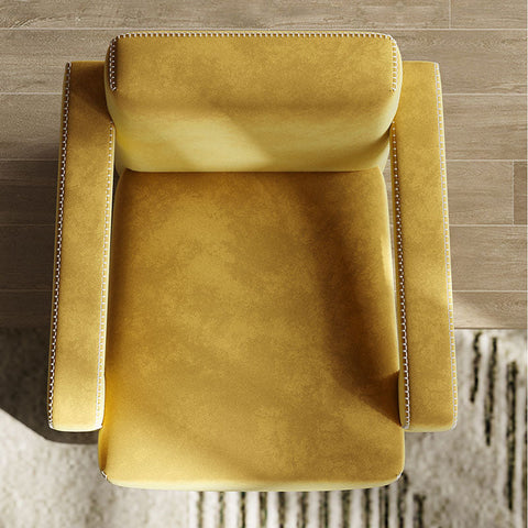 A mustard yellow aspasia armchair with textured fabric and decorative nailhead trim along the edges