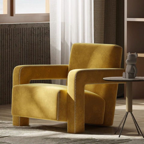A mustard-yellow velvet aspasia armchair with light stitching along its seams for stylish comfort