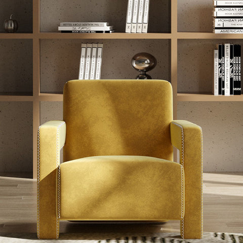 A plush mustard-yellow velvet aspasia armchair with silver nailhead trim perfect for cozy seating