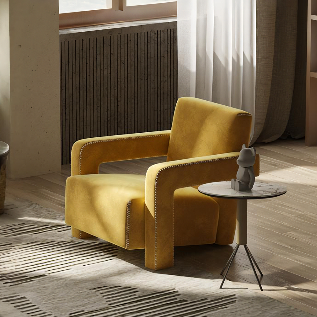 A plush mustard yellow velvet aspasia armchair with stitched detailing along the edges