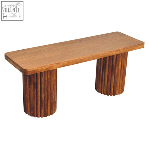 A sleek astoria fluted bench made of natural mango wood with warm-toned finish and fluted cylindrical legs