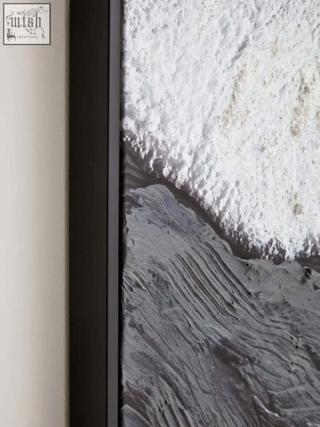 Black-framed wall art featuring earthy tones textured monochromatic waves crashing on rocky shore tones textured wall