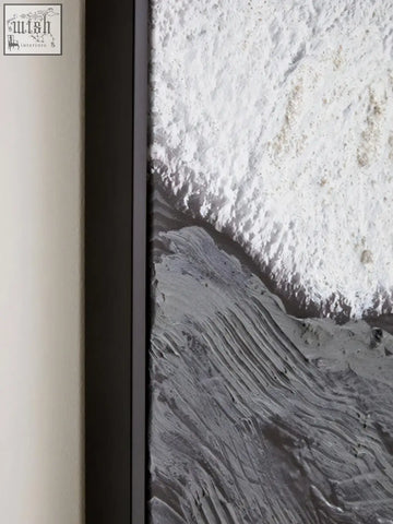 Black-framed wall art featuring earthy tones textured monochromatic waves crashing on rocky shore tones textured wall