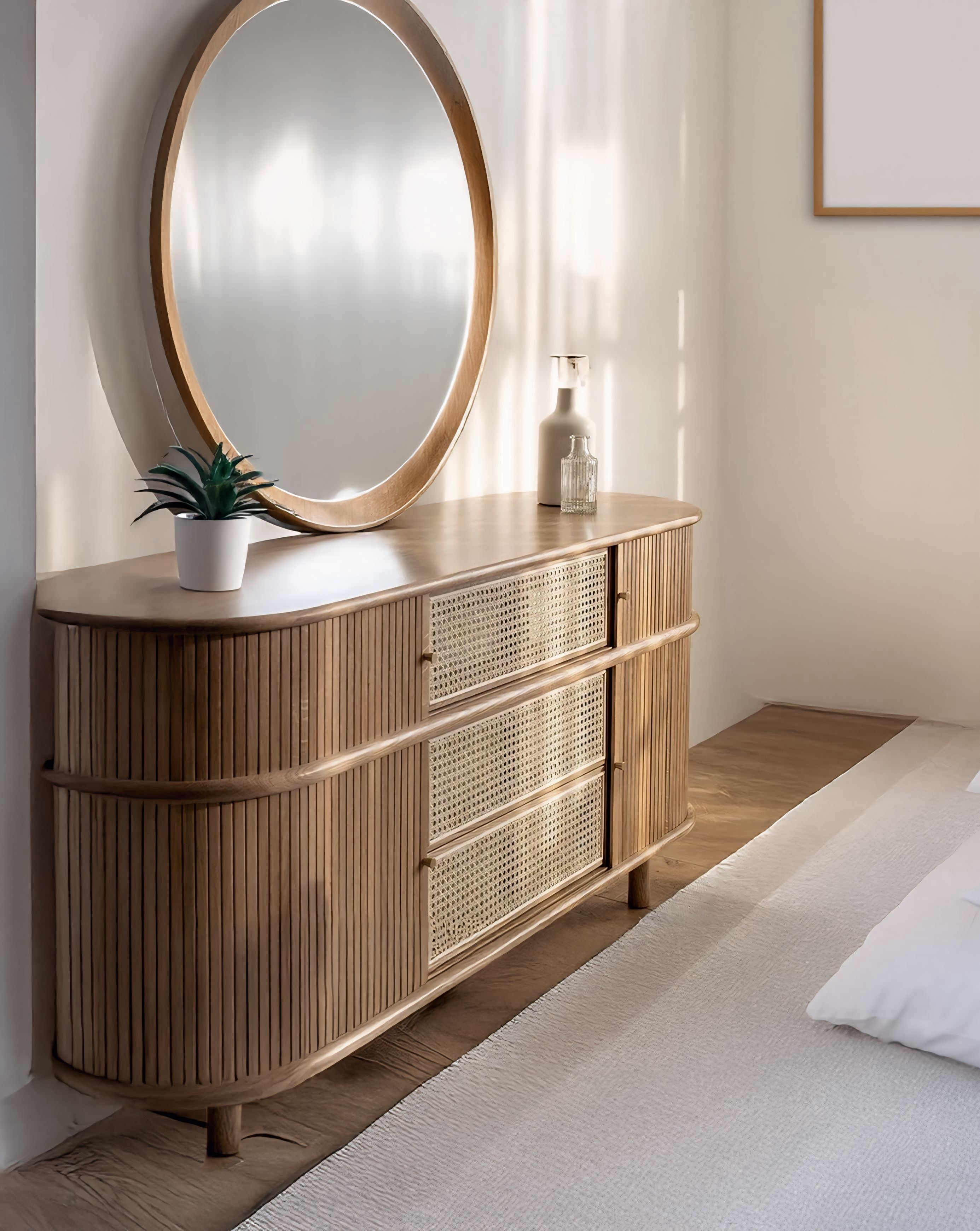 Light wood finished asuka cabinet with vertical slats and woven cane drawers topped by a matching round mirror