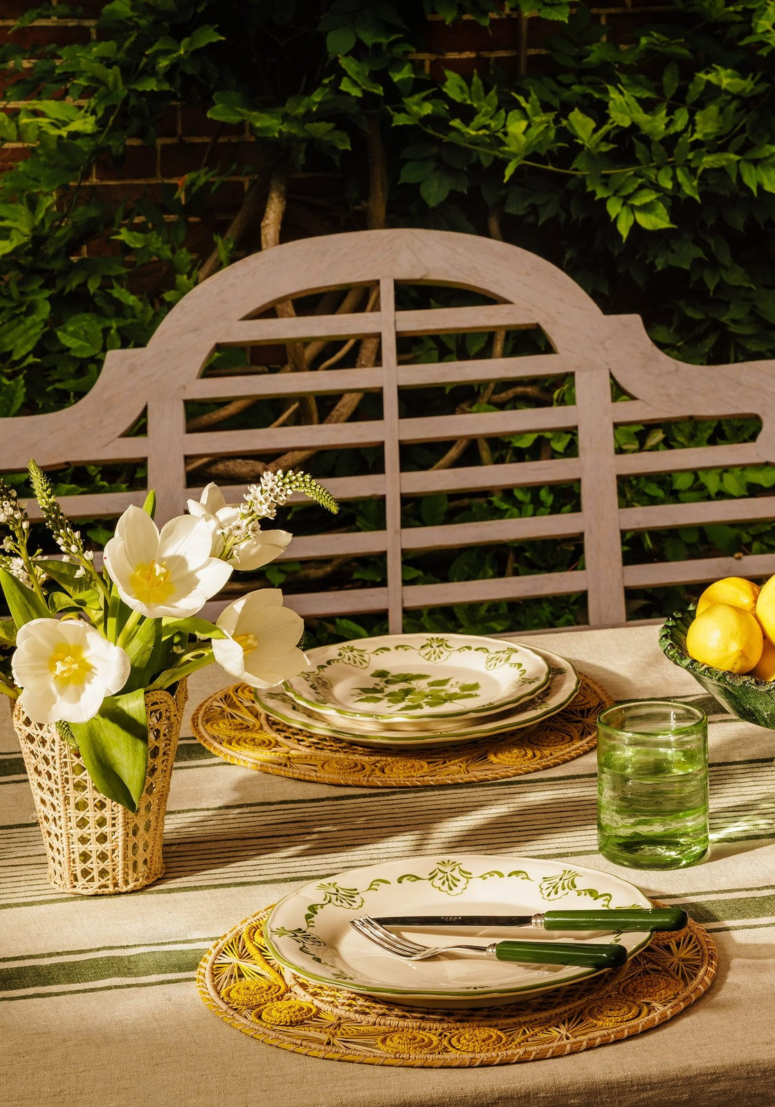 White ceramic plates with green leafy patterns on yellow atlántico iraca woven placemats for dining use