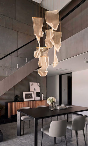 A modern atsushi light chandelier with flowing translucent beige mesh panels hanging from the ceiling