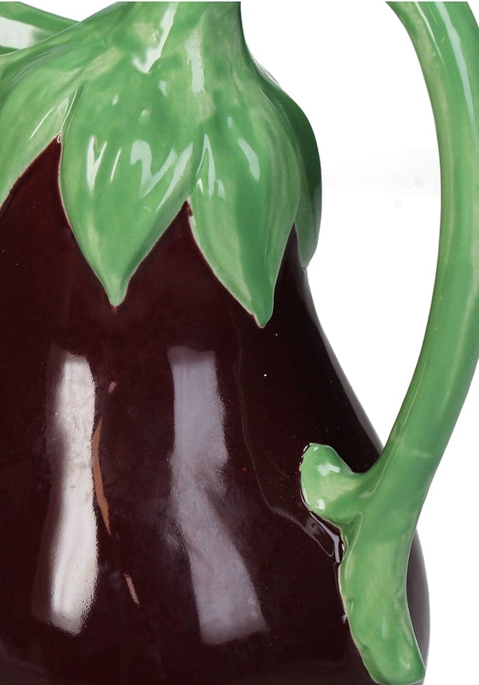 A glossy dark purple ceramic aubergine jug shaped like an eggplant with a green leafy top and stem handle