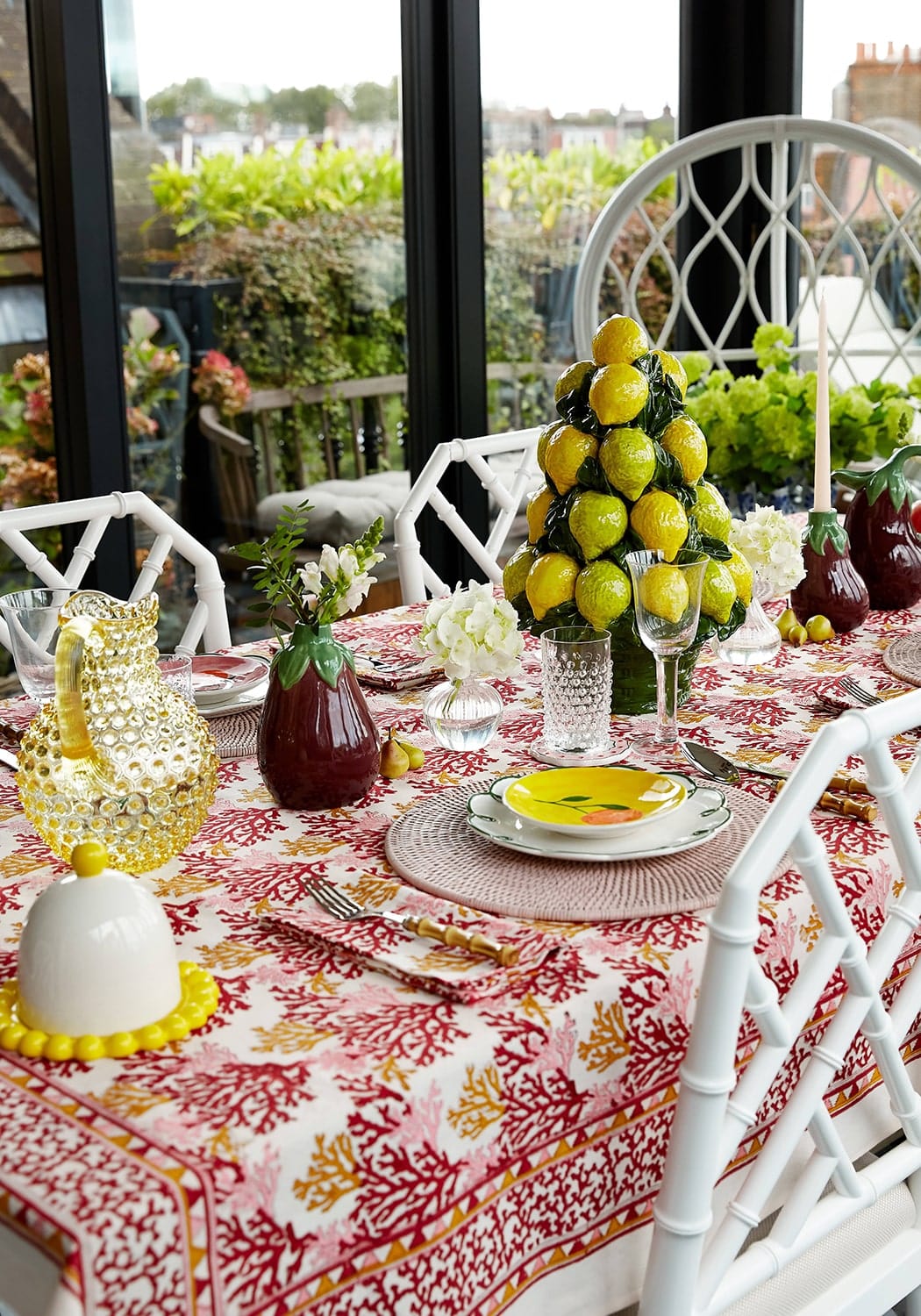 Aubergine jug on a vibrant coral patterned tablecloth with red pink and gold accents perfect for serving drinks