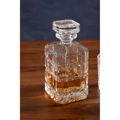 Clear crystal auclair decanter with faceted square body and amber liquid, paired with two tumblers for serving drinks