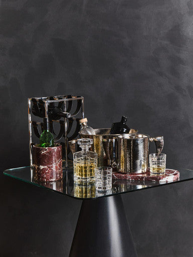 A sleek metallic silver auclair decanter with a faceted glass body and stopper plus two tumblers