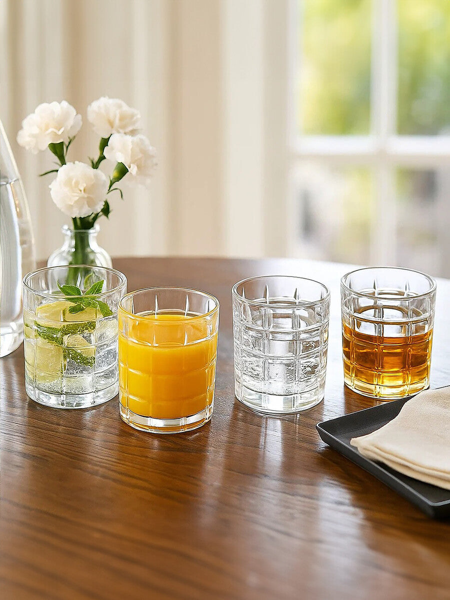 Set of four check glass Auclair tumblers clear textured glass with grid patterns and assorted drinks inside