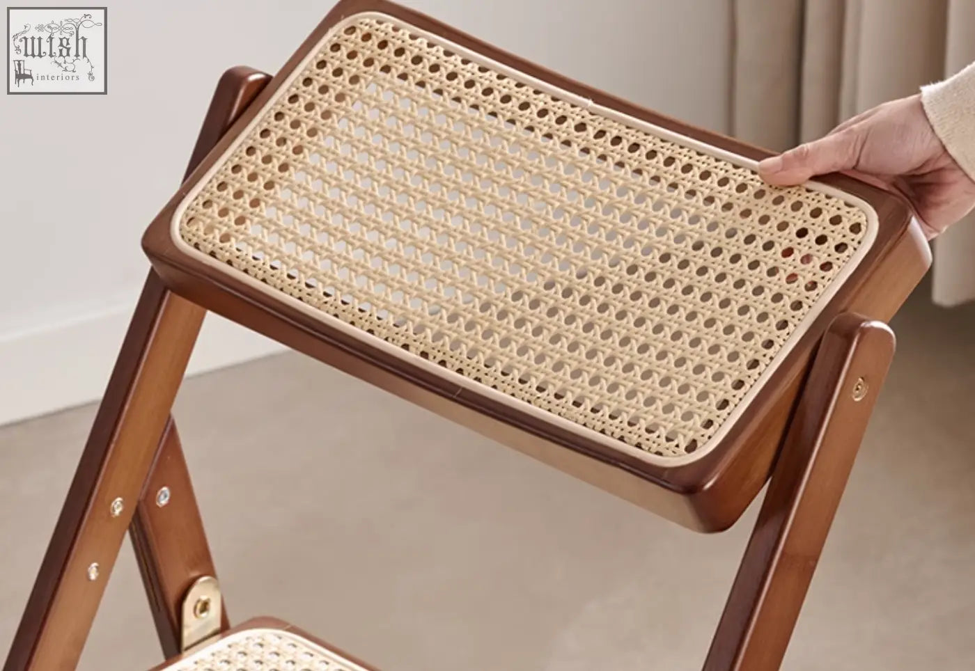 Audrey folding dining chair with a beige woven rattan cane seat and polished dark wood frame perfect for dining