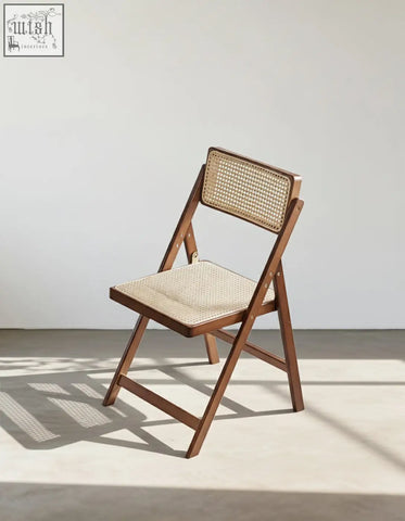 Audrey folding dining chair with a warm brown wooden frame and woven rattan backrest and seat perfect for dining