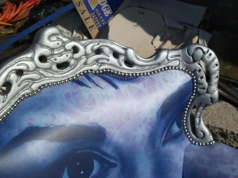 Silver ornate picture frame with beaded trim and scrollwork design on audrey hepburn chair