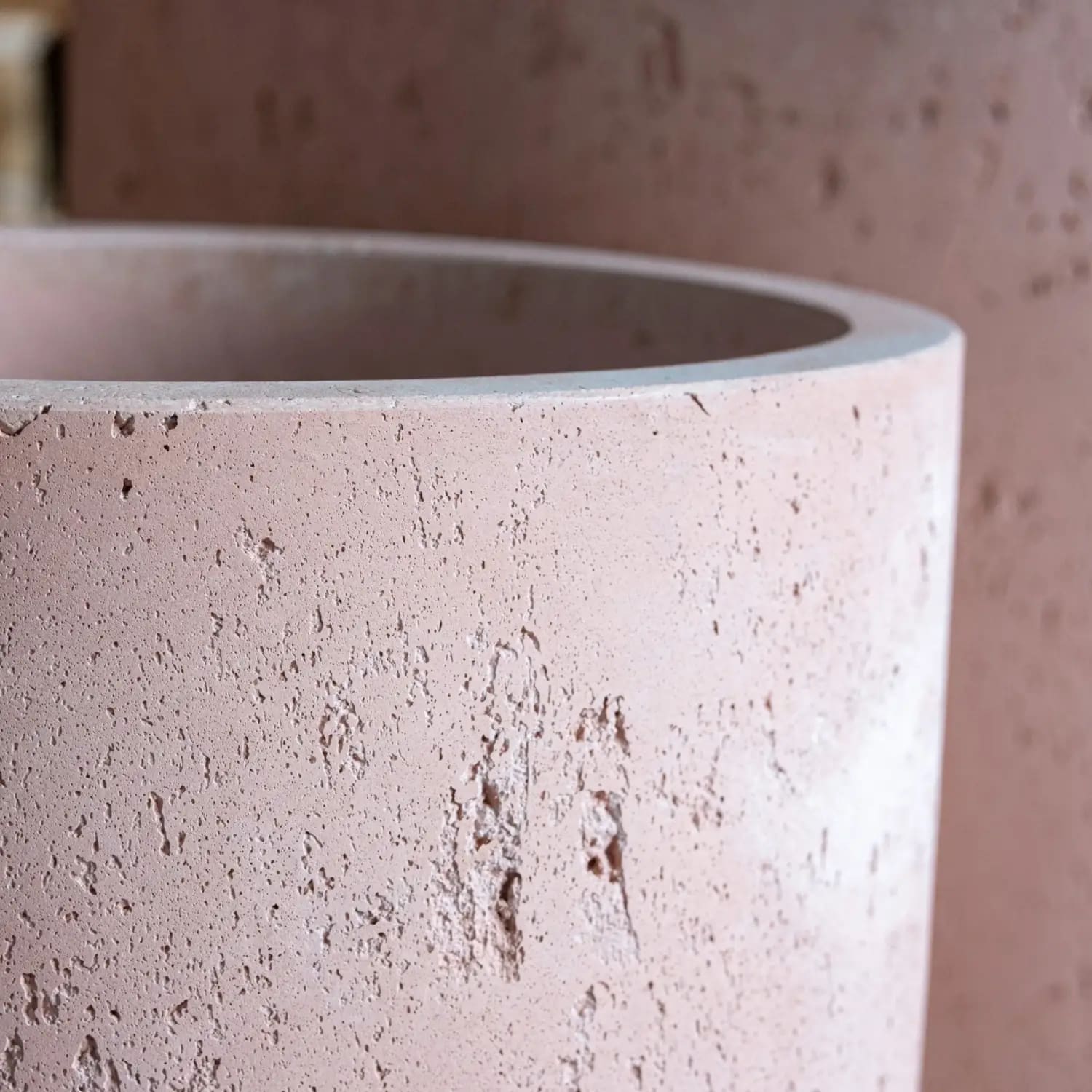 A matte pink blushstone colourway concrete cylinder planter with textured surface works beautifully on kitchen counters