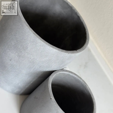 Gray concrete cylindrical plant pots with a matte textured finish in brushed grey stone resin for indoor use set of 2