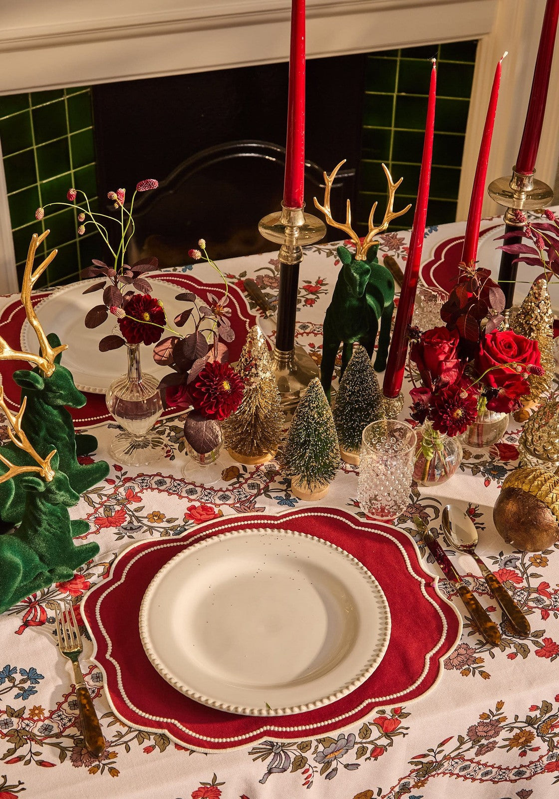 White ceramic plate with scalloped edge and speckled texture on red velvet placemat with red slender taper candles
